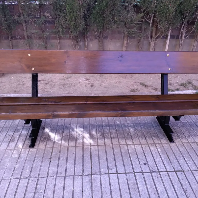 Banco de madera de exterior después de lijar y barnizar, con la madera uniforme y protegida