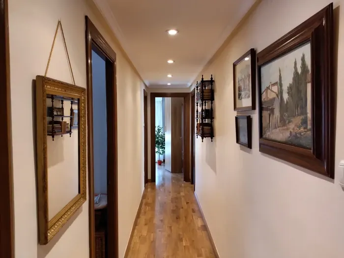 Pasillo de vivienda con paredes pintadas en tono claro y techo blanco