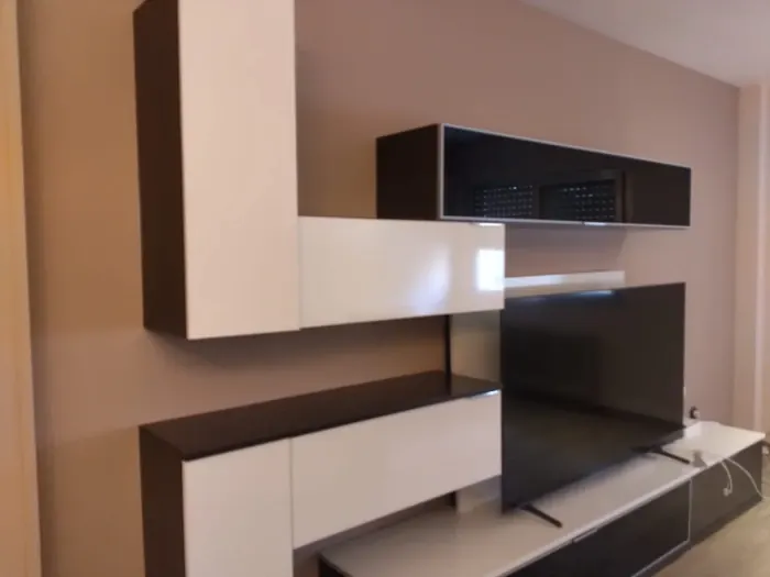 Salón con pared pintada en tono malva detrás del mueble de televisión